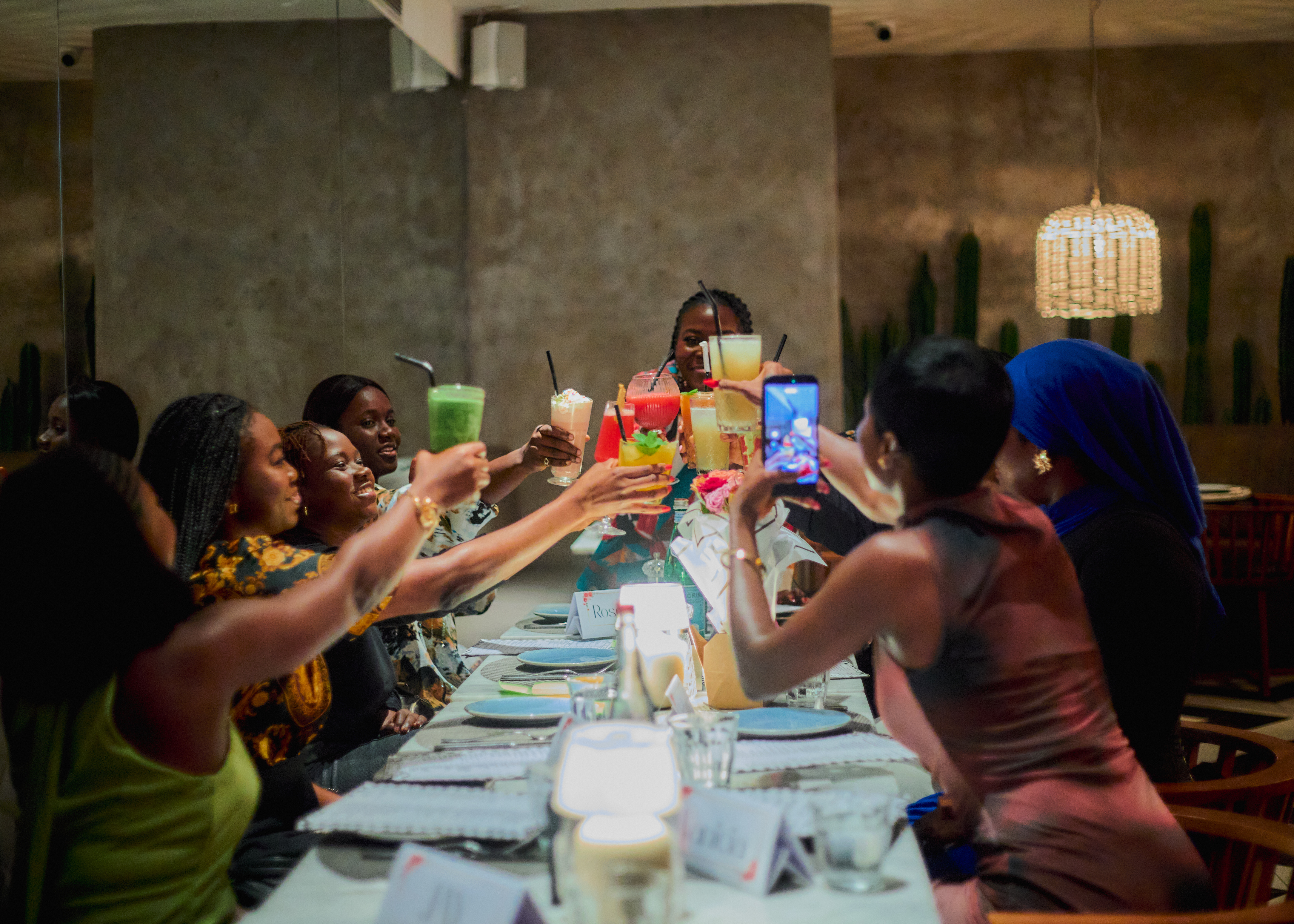 Women raising glasses together around the first Ambition Table